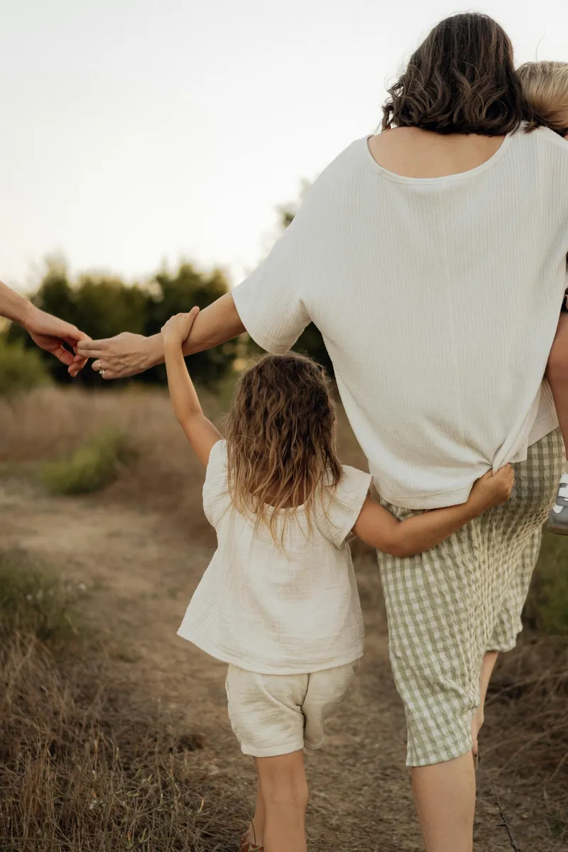 A parent and child walking together on a nature path at sunset